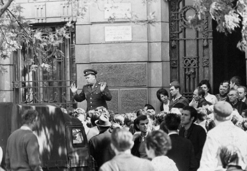 Košice residents jeer at a member of the Czechoslovakian army as headdresses them outside the city h