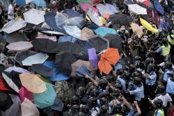 shihlun:  Hong Kong protesters used a blanket of umbrellas to protect themselves as police fired tear gas. Photo by Alex Ogle 