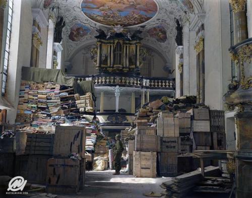 historicaltimes: A US soldier stands amid crates and stacks of loot stored by Nazi Germany in Schlos