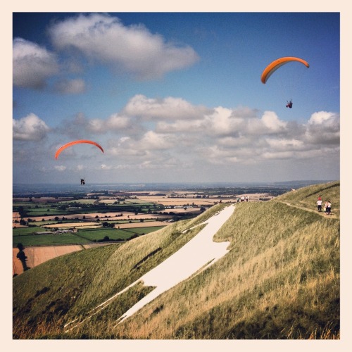 Madmen hanging from kites over the Westbury White Horse. Wiltshire, England.