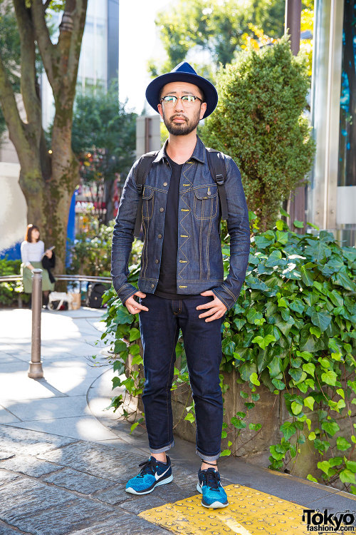 Japanese designer Shinya on the street in Harajuku wearing a hat and glasses, an AKM x Lee denim jac