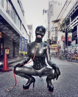 sutiblr:  Silver latex catsuit with rubber mask in public 