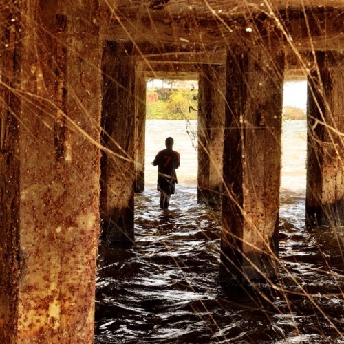 A Young Man Fishing Under The Pier At The Uganda Wildlife Education Centre Www.uweczoo.org In Entebbe,
