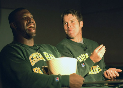 Green Bay Packers defensive end Reggie White laughs as he shares a tub of popcorn with quarterback B