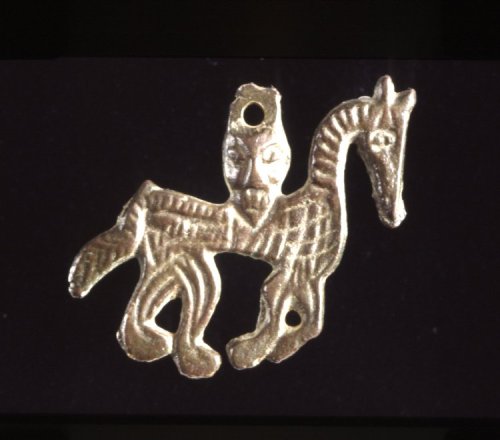 artofthedarkages:A small pendant in the shape of a horse with a head loophole, incised with linear d