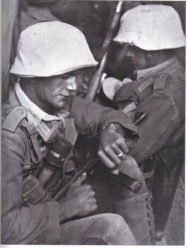 A Grenadier checks his watch while waiting undercover with his comrades shortly before launching an 