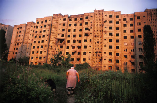 untrustyou:  Jonas Bendiksen Abkhazia. Sukhum. 2005: Babushka “Tanya,” an elderly ethnic Russian woman, heads back to her bombed-out apartment building after walking her dog. Despite the damage, three apartments remain occupied in the building.