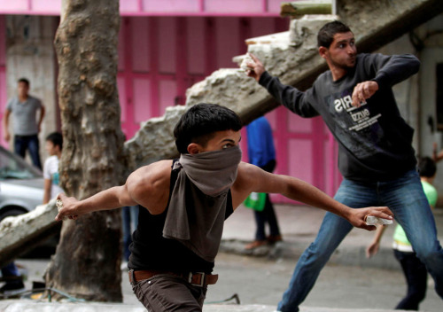 Palestinians throw stones towards Israeli soldiers, not pictured, during clashes in the West Bank ci