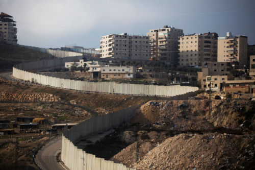 Israel’s separation wall can be seen next to the Palestinian Shuafat refugee camp on January 2