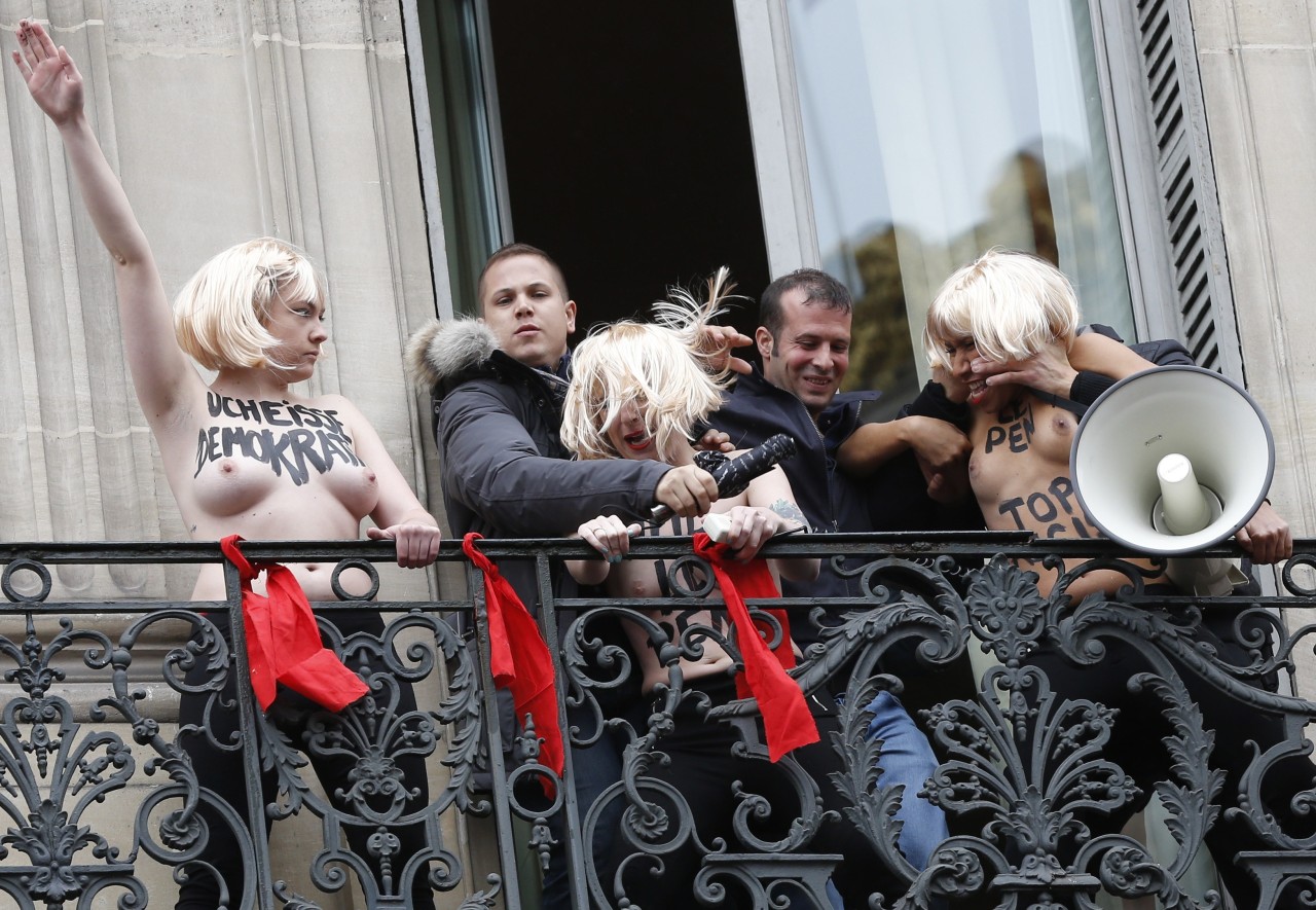 FEMEN. Los guardias de seguridad detienen a activistas de Femen en topless que realizan el saludo nazi desde el balcón contra el partido político Frente Nacional de Marine Le Penn de extrema derecha de Francia durante un mitin FN en honor a Juana de...