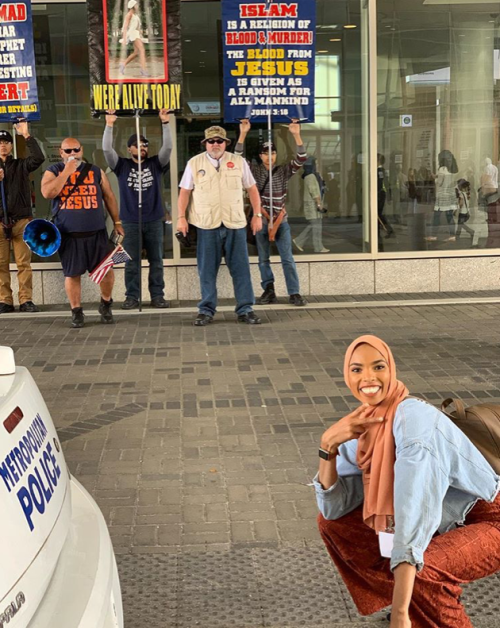 blackfemmeguide:halalhumour:This Muslim woman took a photo in front of an anti-Muslim protest like a