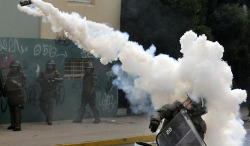 politics-war:  A riot police officer throws a tear gas canister at students during a demonstration against the government to demand changes in the public state education system in Valparaiso city, Chile, on June 26, 2013. 