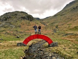sixpenceee:  A Glueless Paper Bridge That You Can Walk OverBritish artist Steve Messam has installed a bright red, weight-bearing arch bridge across a stream in the rural Lake District National Park of Cumbria, in UK, using nothing but 22,000 sheets of