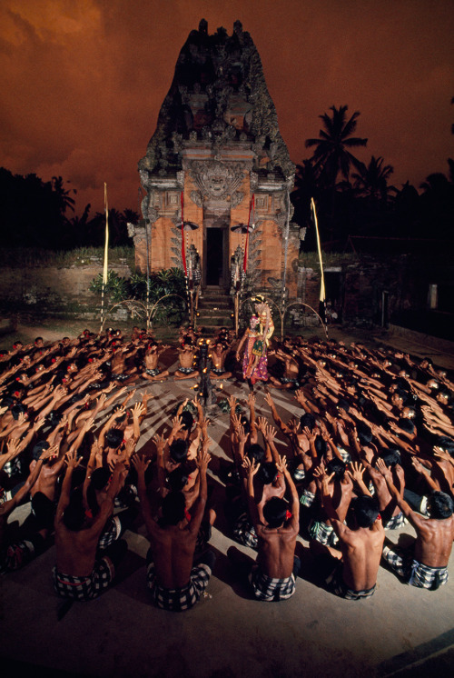 Seated villagers wave arms as they enact a play in front of a temple in Bali, Indonesia, 1969. Photo