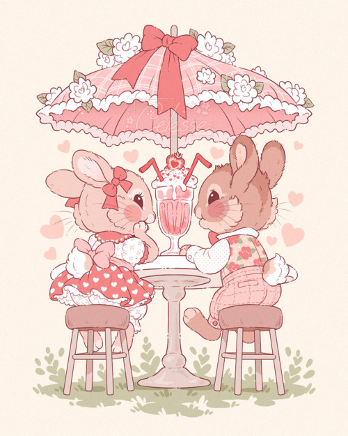A vintage-style drawing of two rabbits, one in a dress and one in vest and checkered pants, sitting on stools at an outdoor table under a lacey umbrella with a big bow and flowers on top. They are looking happily at each other and a strawberry milkshake with two straws sits on the table between them.
