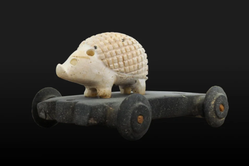 historical-nonfiction: Limestone hedgehog on its own wheeled vehicle. Found near the temple of Inshu