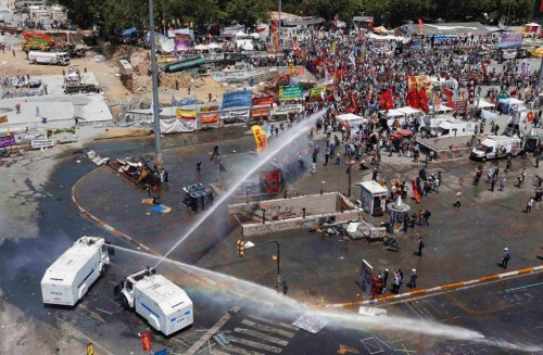 Police Enter Taksim Square in Istanbul1. Protesters take cover from a police water cannon during cla