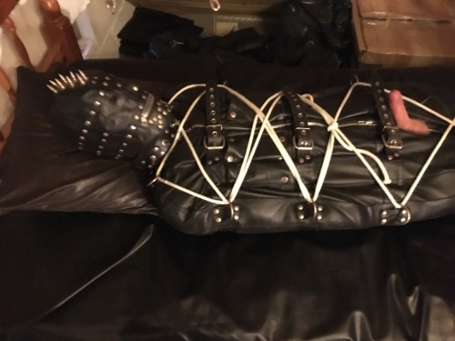 jamesbondagesx:  Gimp in full rubber, rubber hood, leather gimp hood, leather sleepsack roped up tight and milked 