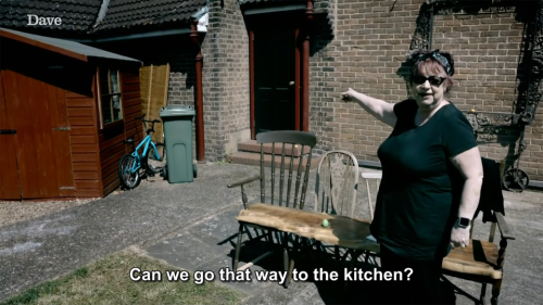 [ID: Four screencaps from Taskmaster. Jo Brand stands in a garden, pointing at the black back door o