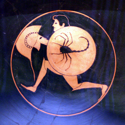 A running hoplite.  Tondo of a red-figure kylix signed by the potter Pamphaios; decoration attribute