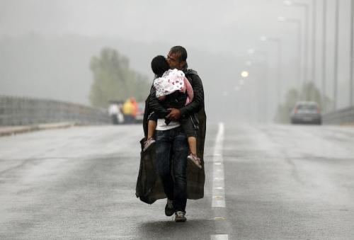 unrar: A Syrian refugee kisses his son as he walks through a rainstorm towards Greece’s border