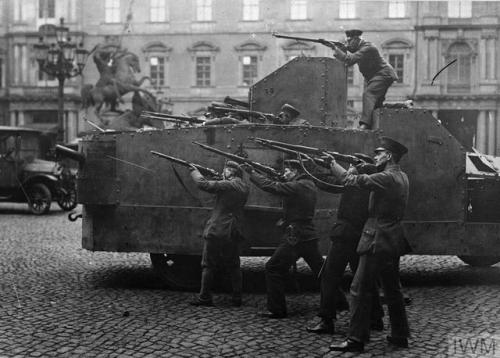 Revolutionary soldiers and sailors surround Berlin Castle. The photo caption says they are firing at