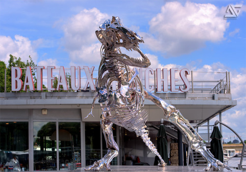 2headedsnake:  Philippe Pasqua recently completed an installation of a Tyrannosaurus Rex skeleton that now stands watch over the Seine river in Paris. the structure is made from 350 chrome molded bones and measures a full 21’ x 12’. Philippe Pasqua