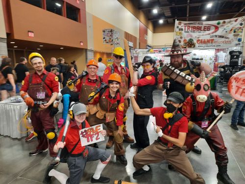 The whole group in the Meet the Team pose. There's two scouts, four engineers, one sniper, one heavy, and one pyro. The scouts is holding a sign that reads #SaveTF2