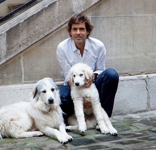 Pierre Yovanovitch sits with Stella, his Great Pyrenees, and Fuji, an Abruzzese shepherd puppy. Phot