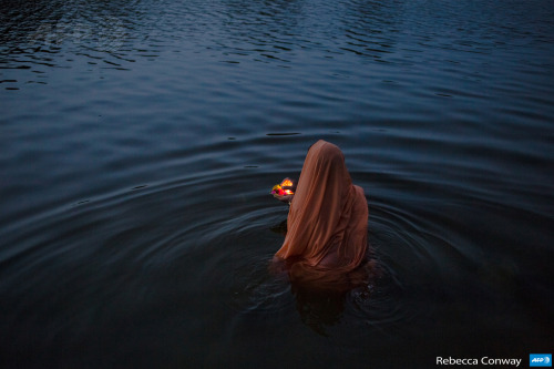 bombaynights:An Indian women offers early-morning prayers or a ‘puja’ at a ghat early in the morning