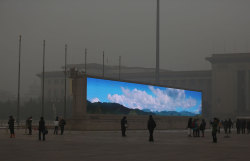 sharedontshare:  A bright video screen shows images of blue sky on Tiananmen Square during a time of dangerous levels of air pollution, on January 23, 2013 in Beijing. (Feng Li/Getty Images) (via  In Focus - The Atlantic)