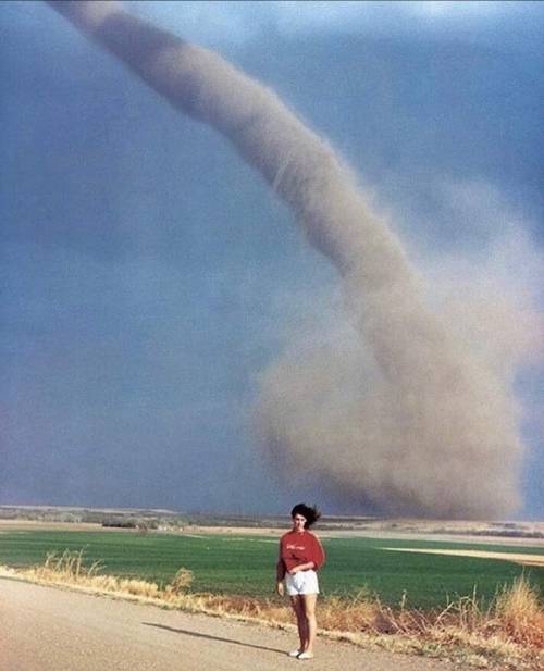 aiiaiiiyo:Girl posing in front of an actual tornado. Photo was taken by her mother. (Nebraska, 1989) Check this blog!