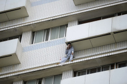  A patient sits outside a hospital building