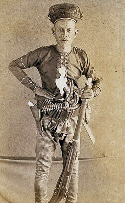 Hadji Abdullah of Jolo (the Philippines) posing with his bolo, pearl handled revolver, and krag rifl