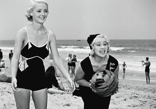 gingerrogerss:  Bette Davis and Joan Blondell play ball at the beach in Three on
