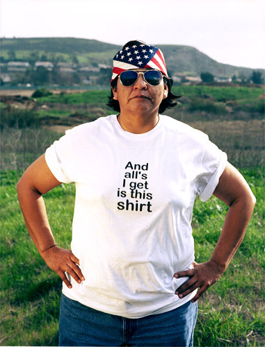 terresauvage:   “Shelley Niro parodies the archetypal tourist tee-shirt from the point of view of First Nations Peoples as an exploration into the lasting effects of European colonialism in North America. Facing the camera directly and poised against