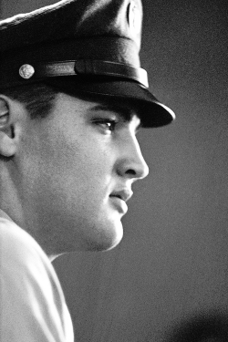 vinceveretts:  Private Elvis, in profile after having been given the typical military crew cut, awaits to board the USS Randall on its way to Germany, to perform occupation duty. Brooklyn Army Terminal, September 22, 1958. © Alfred Wertheimer  
