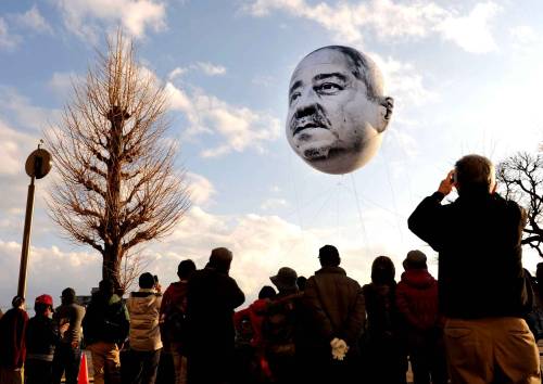 ofools:hollowedskin:shihlun:A giant helium balloon bearing the face of an ojisan (middle-aged man) a