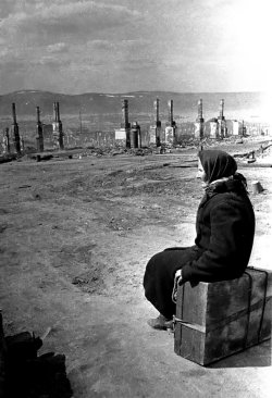 bag-of-dirt:  An elderly Russian woman rendered homeless by the near destruction of Murmansk sits upon her suitcase and ponders where to go. The Germans launched an offensive against the city in 1941 as part of Operation Silver Fox; the main goal was