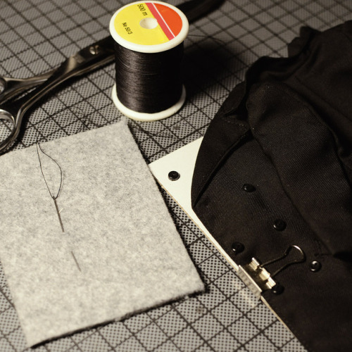 Toy problems: Sewing on a button on a vintage doll coat.