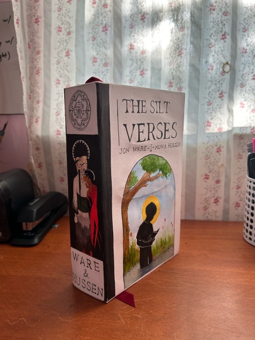 ID: The book standing up on a desk so that the front cover and spine are visible. /end ID