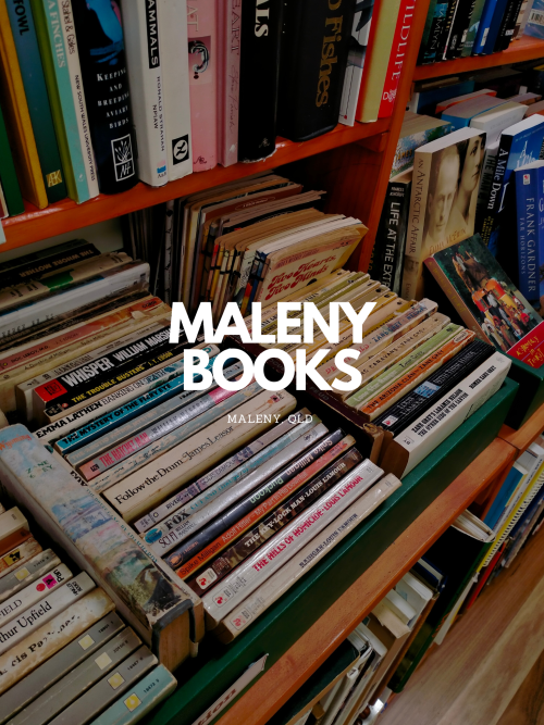 An askew wide angle shot of rows of books, with multicoloured book spines. The text overlay is in bolded white font that states 'Maleny Books, Maleny Queensland'.
