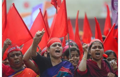 Bangladeshi activists shout slogans and wave flags during a procession to mark May Day or Internatio