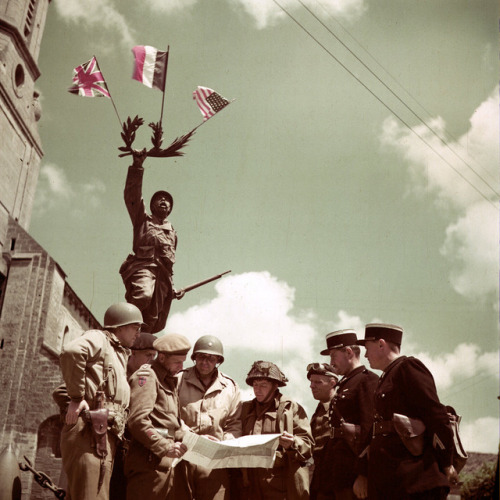 US, British, Canadian, and French servicemen in front of the World War I monument, Creully/June 1944