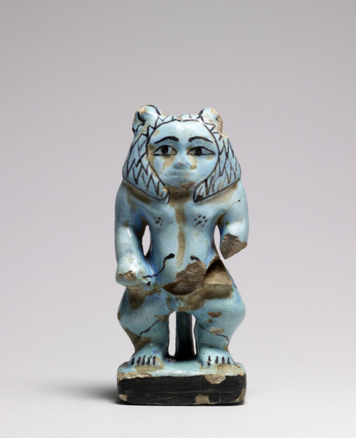 Faience protective figure of the ancient Egyptian dwarf god Bes, shown here with a lion’s mane and g