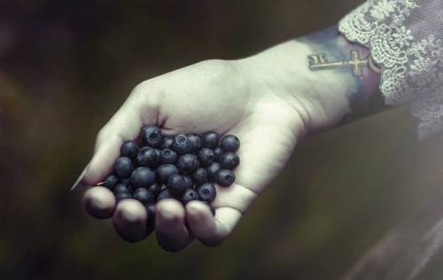 Her white-bone hand outstretched, palm piled with glistening black berries. Poison or pleasure? Or p