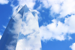 lensblr-network:  I recently visited New York, and this is one of the newer buildings in the World Trade area. I thought it was interesting that all the new buildings, rather than stand in contrast with the sky, were almost desperate to be a part of it.