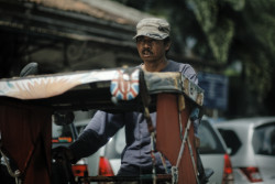Becak driver rides his becak empty. Bandung, Indonesia