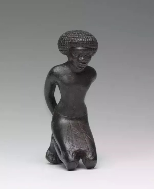 Figure of a Nubian captive, reportedly from Saqqara (bronze, 4.3 x 5.4 x 8.1 cms). New Kingdom, prob