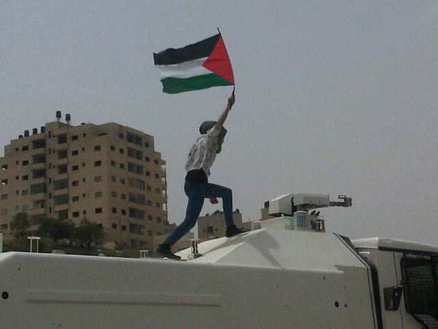 khaste-irooni:  A woman climbs on top of an Israeli riot control truck during a protest.